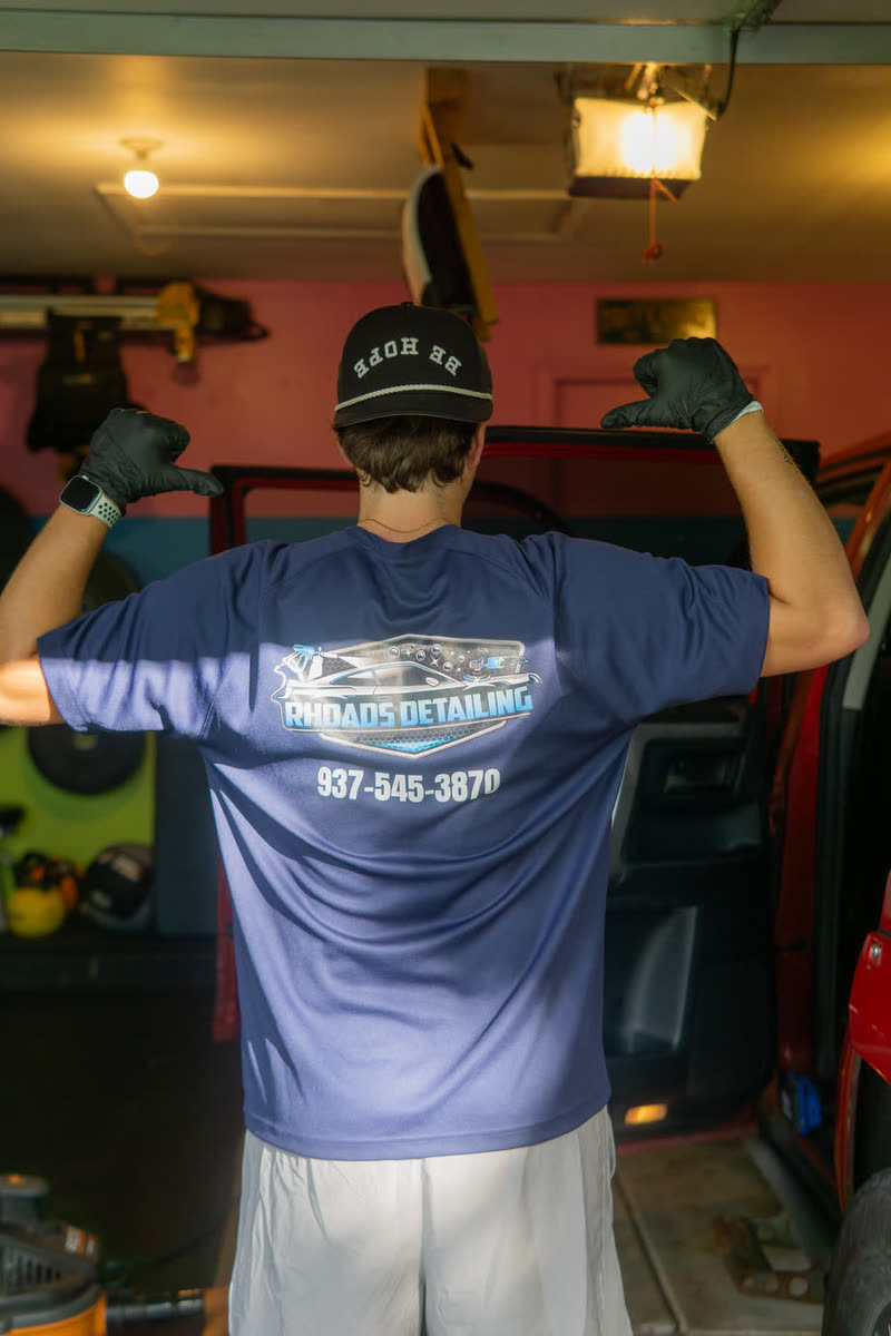 Paden Rhoads in his Rhoads Detailing shirt and BE BOLD cap, at the shop
